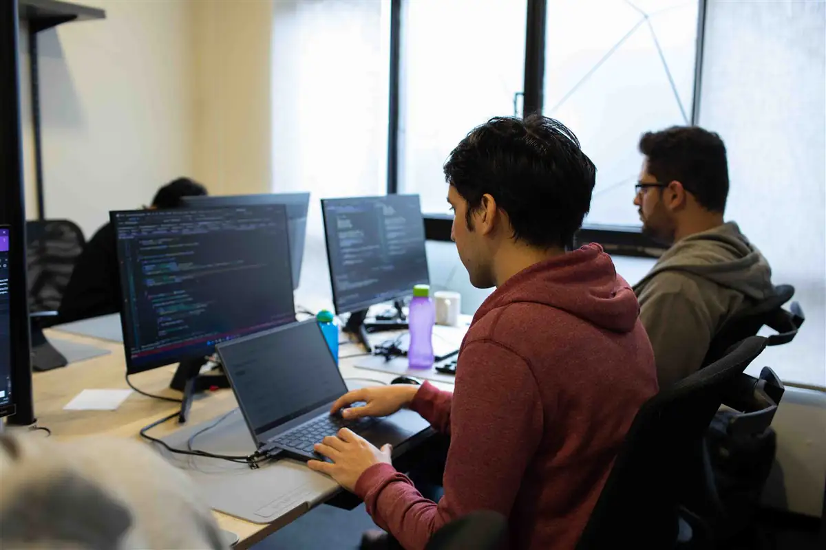 Desarrolladores del equipo trabajando en sus puestos de la oficina